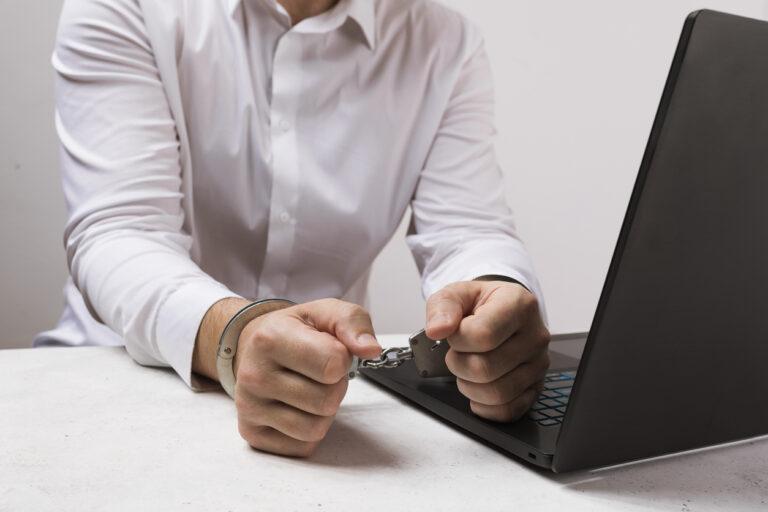 man-in-handcuffs-next-to-laptop