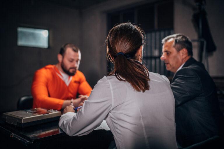 Officers discussing a blue warrant against the male parolee.