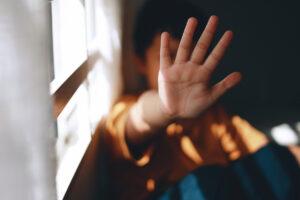 Young boy holding his palm open in a stop gesture showing signs of child pornography in Texas.