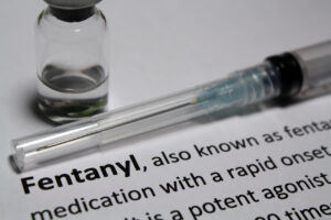 Description of fentanyl beside a syringe and a bottle, suggesting the new "fentanyl" law in Texas.