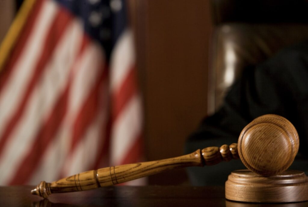Judge’s gavel in front of American flag, symbolizing Texas family violence law and statute of limitations.