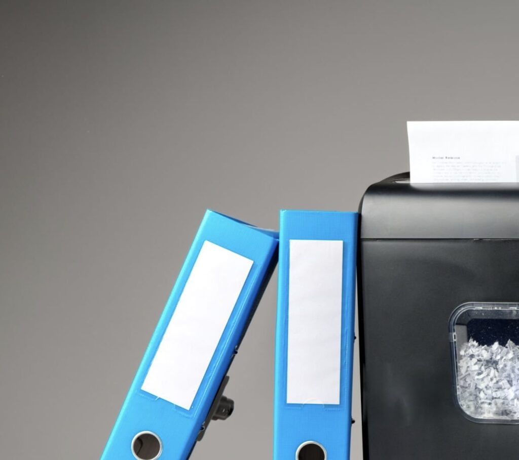 A locked file cabinet next to a paper shredder, representing nondisclosure vs. expunction.