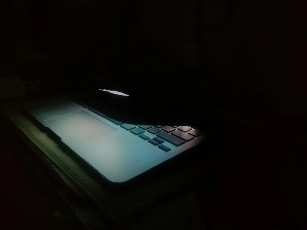 A laptop with a shadowy interface, symbolizing the legal dangers of accessing the dark web for porn.