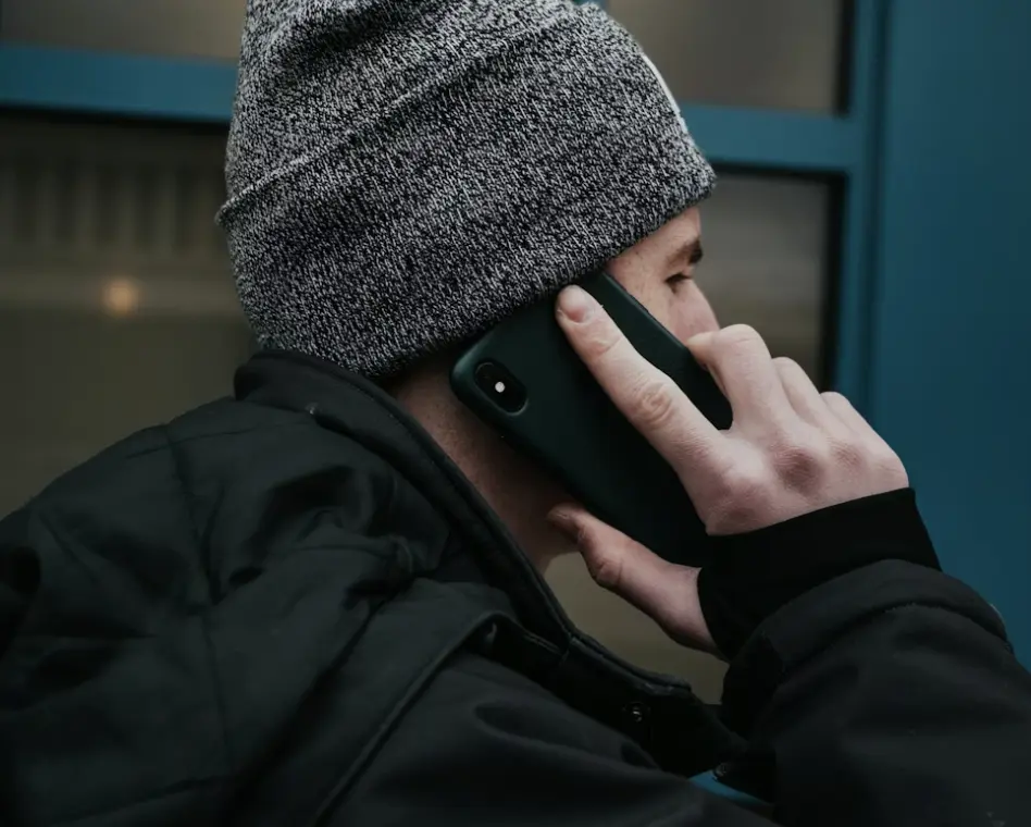 A person making an urgent phone call, symbolizing the immediate need to contact a defense attorney after an arrest.