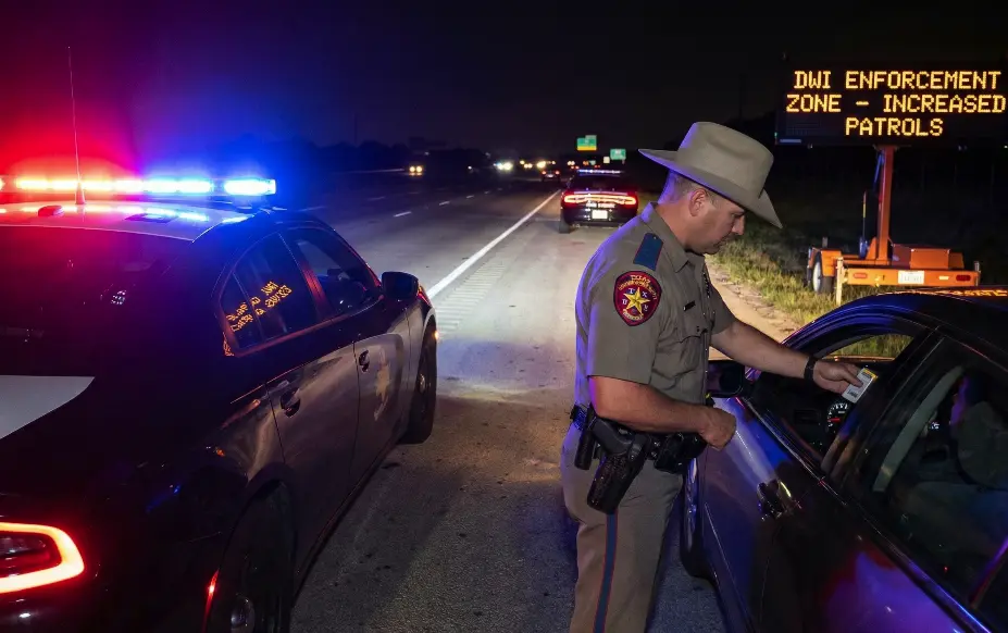 A Texas Highway Patrol vehicle with emergency lights activated during a nighttime traffic stop.